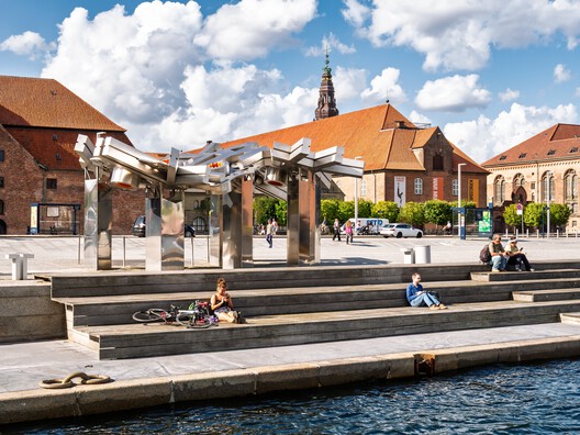 Copenhagen, Denmark - Aug 10, 2024: People relaxing at waterside of Inner Harbor and public art sculpture at Søren Kierkegaards Plads. Image © TasfotoNL via Shutterstock Copenhagen, Denmark - Aug 10, 2024: People relaxing at waterside of Inner Harbor and public art sculpture at Søren Kierkegaards Plads. Image © TasfotoNL via Shutterstock
